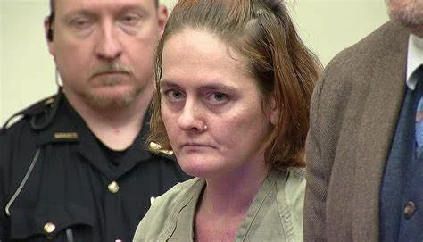 Rebecca Auborn, in jail clothing, seated in an Ohio courtroom beside a deputy