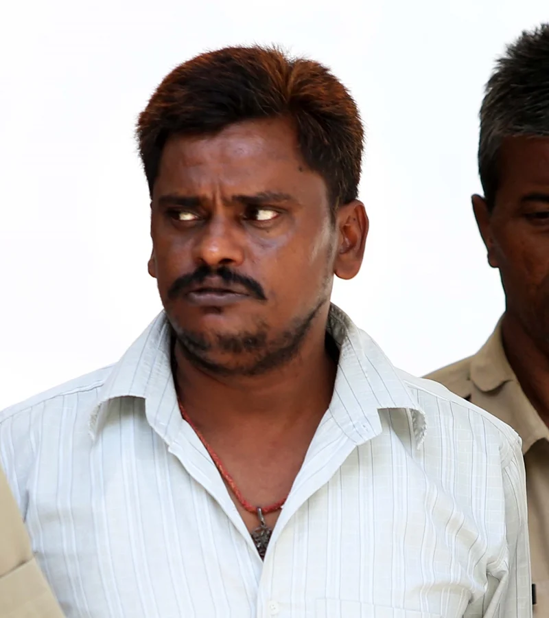 Surendra Koli in a white shirt, photographed outside court