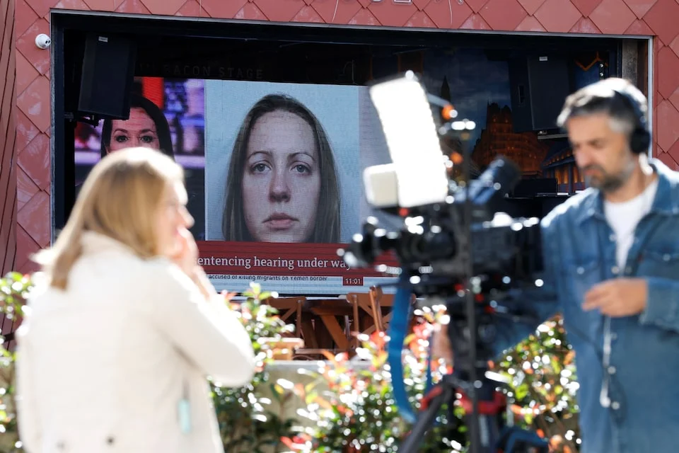 Television crews outside court beside a monitor showing Lucy Letby's photograph