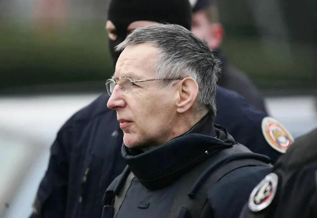 Michel Fourniret, in glasses, escorted by masked French police officers