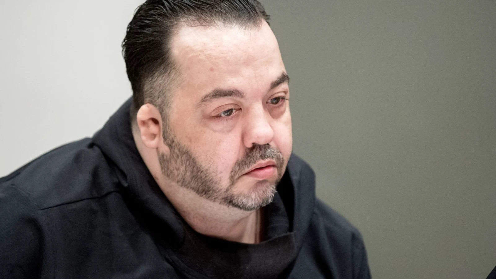 Niels Högel, in a dark hooded top, seated in a courtroom