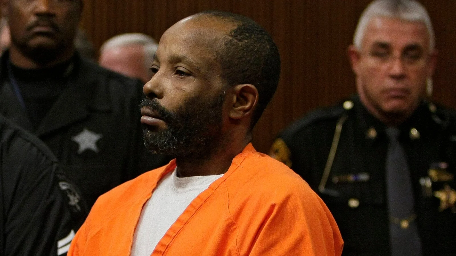 Anthony Sowell in an orange jail uniform in a Cleveland courtroom, with sheriff's deputies behind him