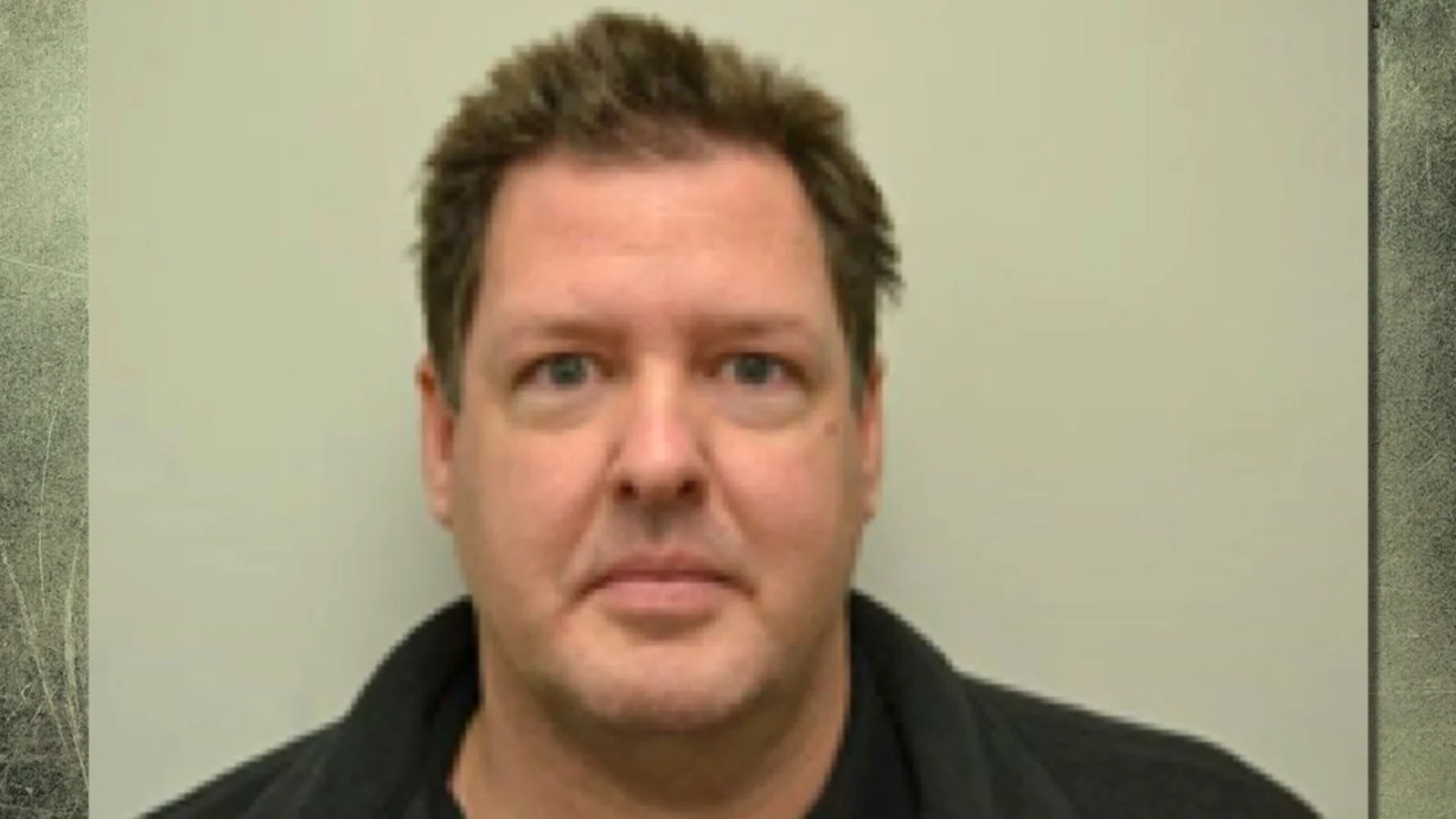 Todd Kohlhepp, dark-haired, in a black top, photographed against a pale wall