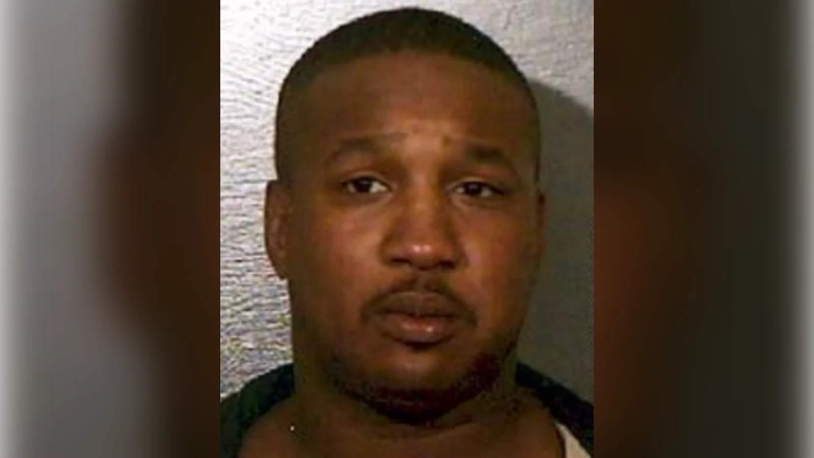Derrick Todd Lee in a police photograph, looking into the camera against a pale wall