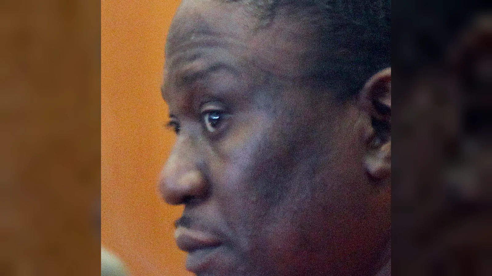 Walter Ellis in an orange jail uniform in a Milwaukee courtroom, seen in profile
