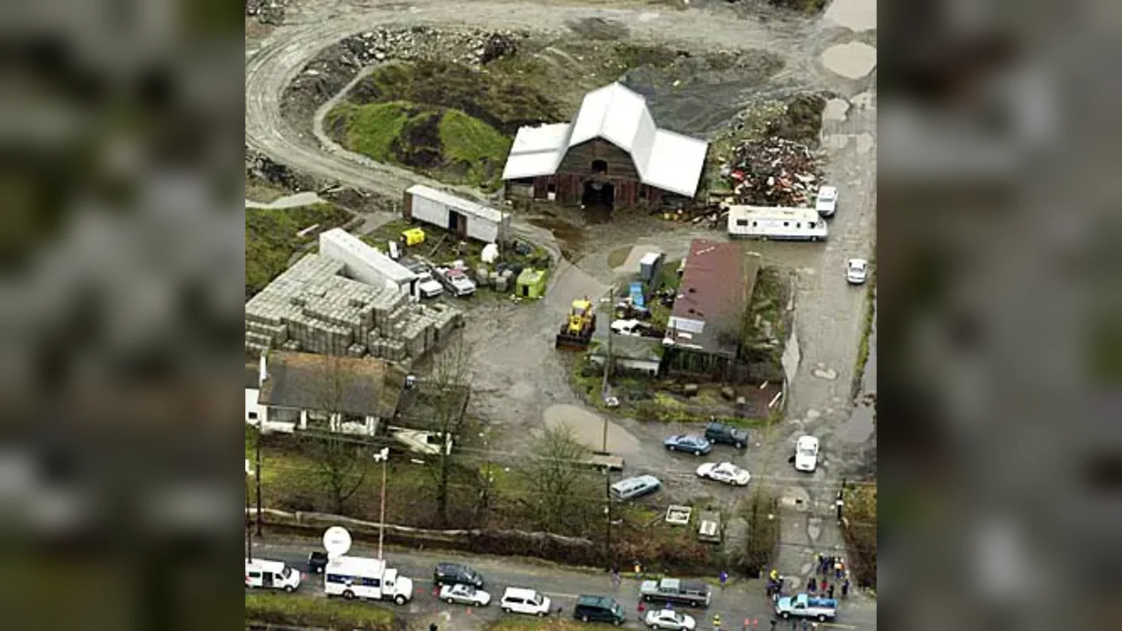 Aerial view of Robert Pickton's farm in Port Coquitlam during the police search, with a barn, trailers and media vans on the road