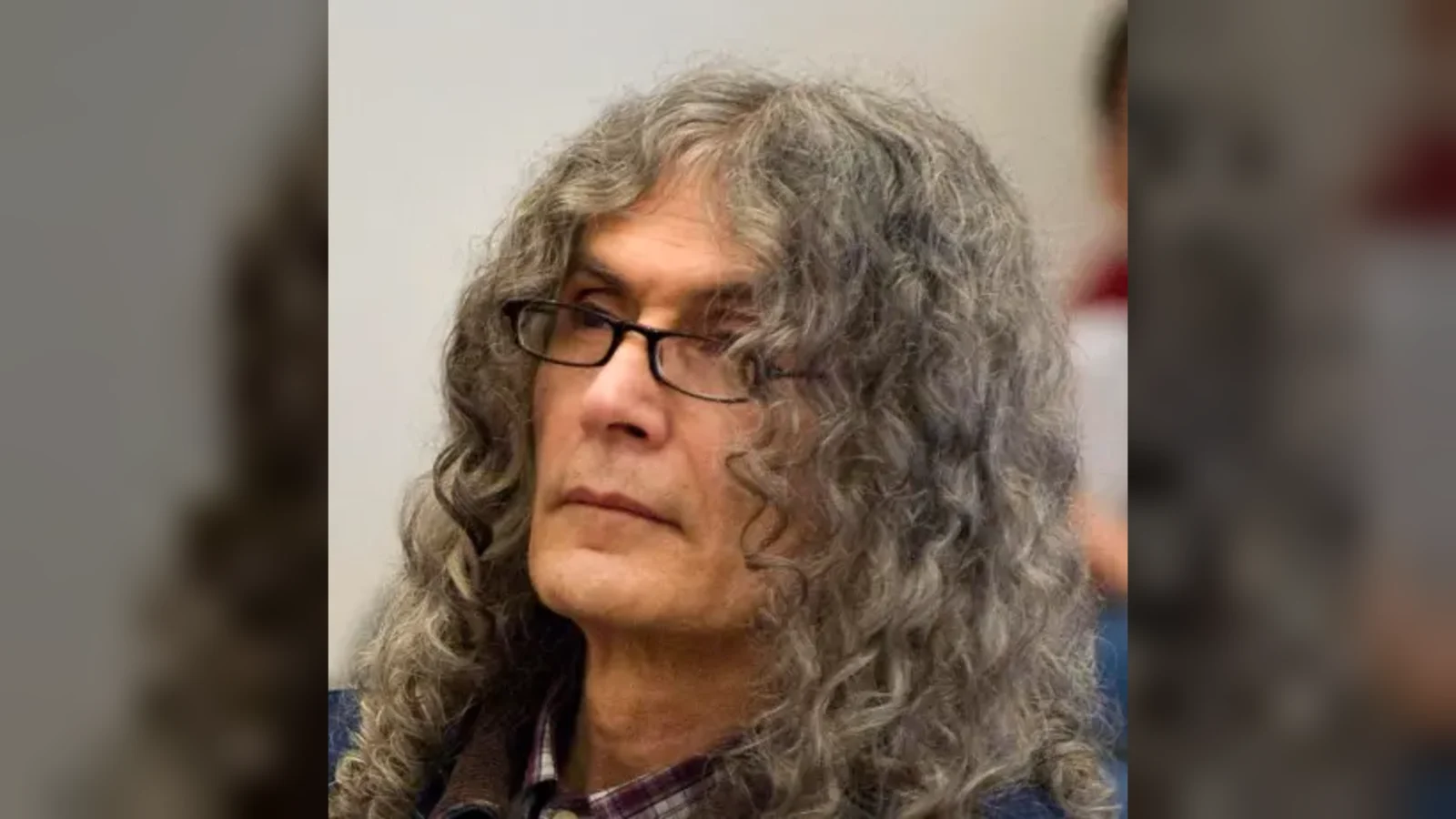 Rodney Alcala, with long gray hair and glasses, seated in a courtroom