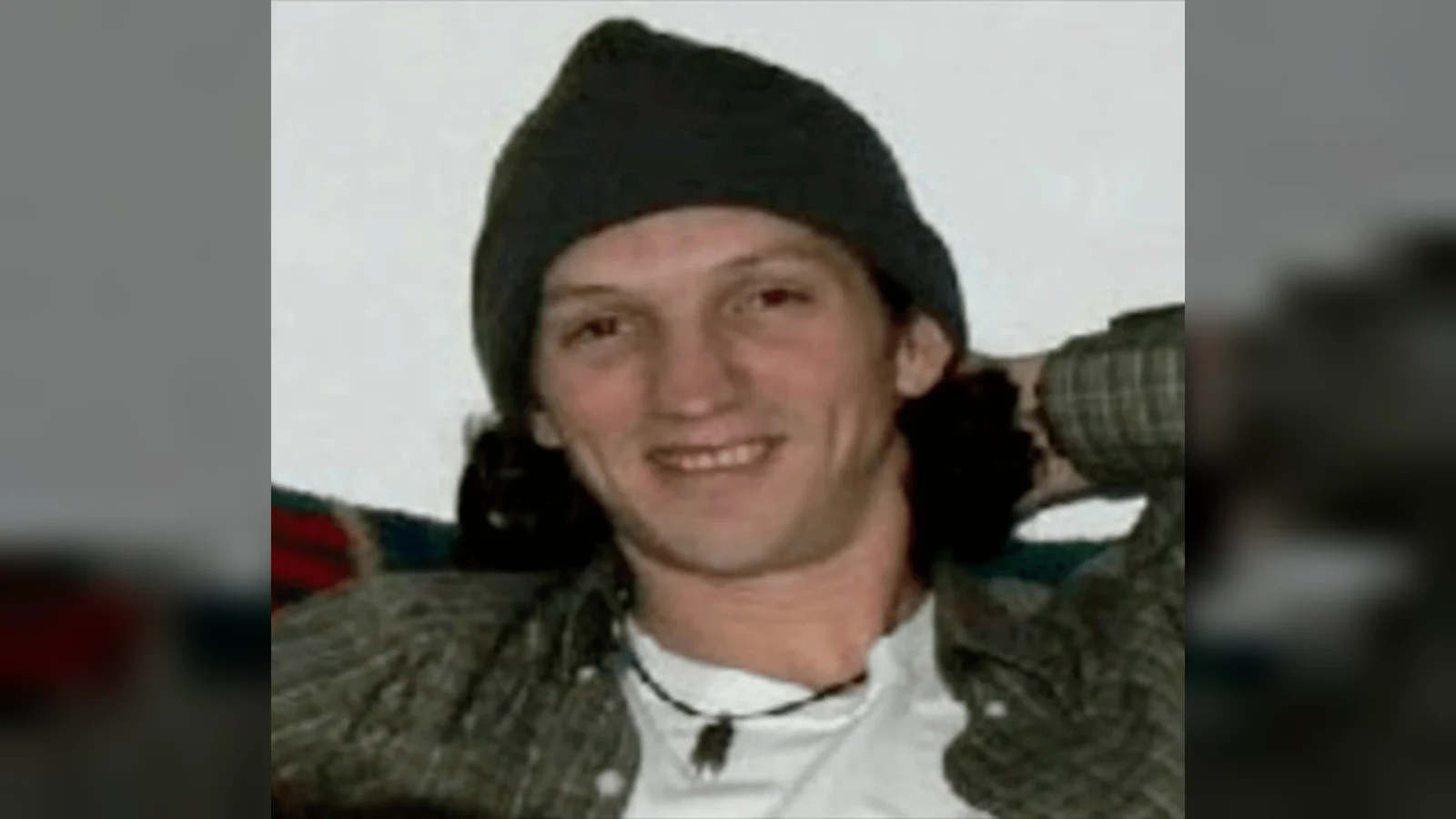 Israel Keyes, smiling, in a dark knit cap and a plaid shirt