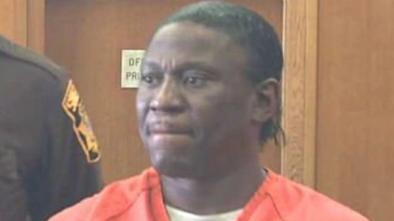 Walter Ellis in an orange jail jumpsuit beside a deputy in a Milwaukee courtroom