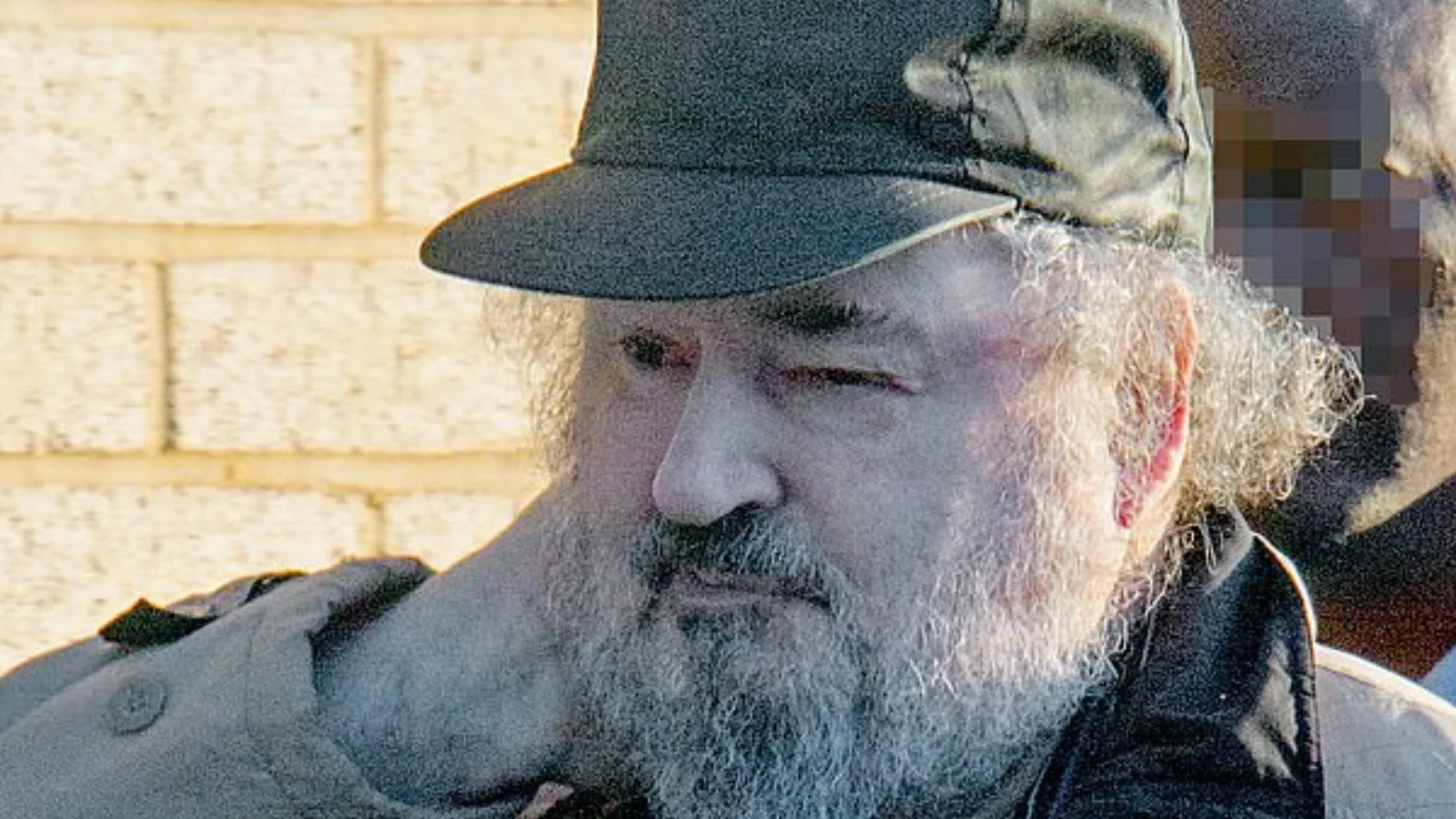 Peter Sutcliffe in later life, gray-bearded and wearing a cap, photographed outdoors