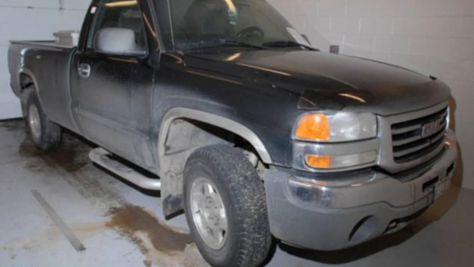 Cody Legebokoff's dark GMC pickup truck parked in a police garage