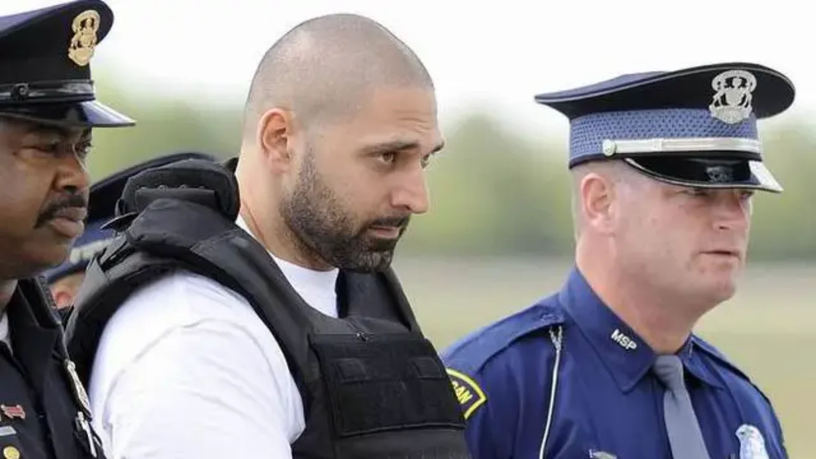 Elias Abuelazam in a protective vest, escorted by Michigan police officers