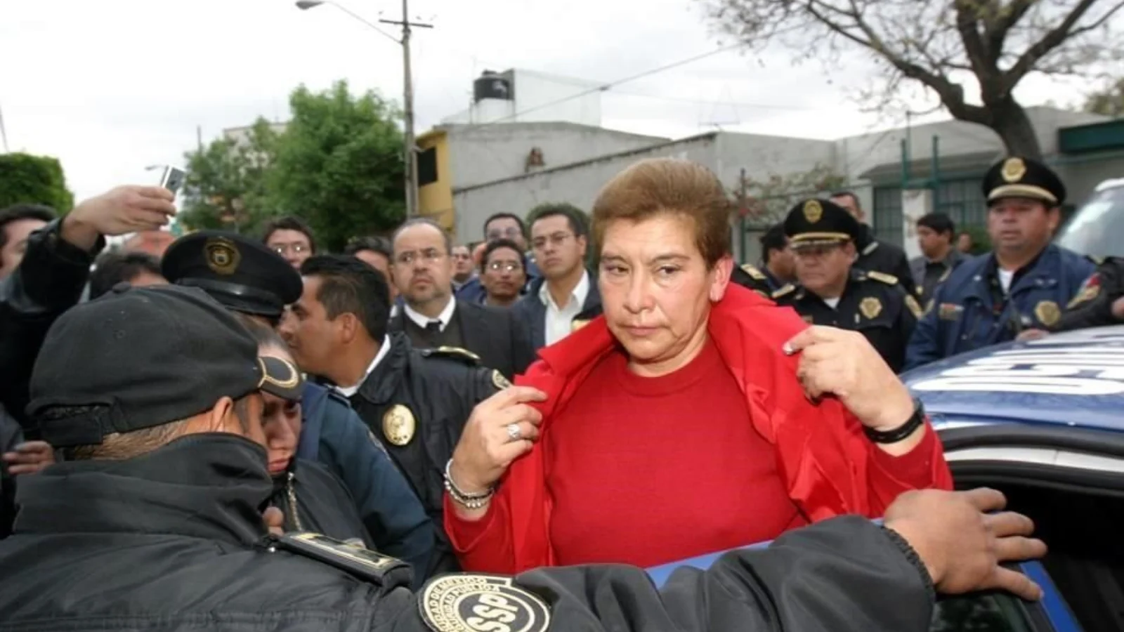 Juana Barraza in a red sweater surrounded by Mexico City police officers