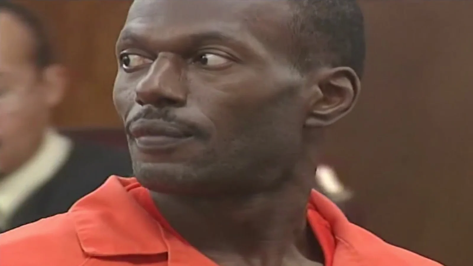 Terry Blair in an orange jail uniform glancing sideways in a Kansas City courtroom