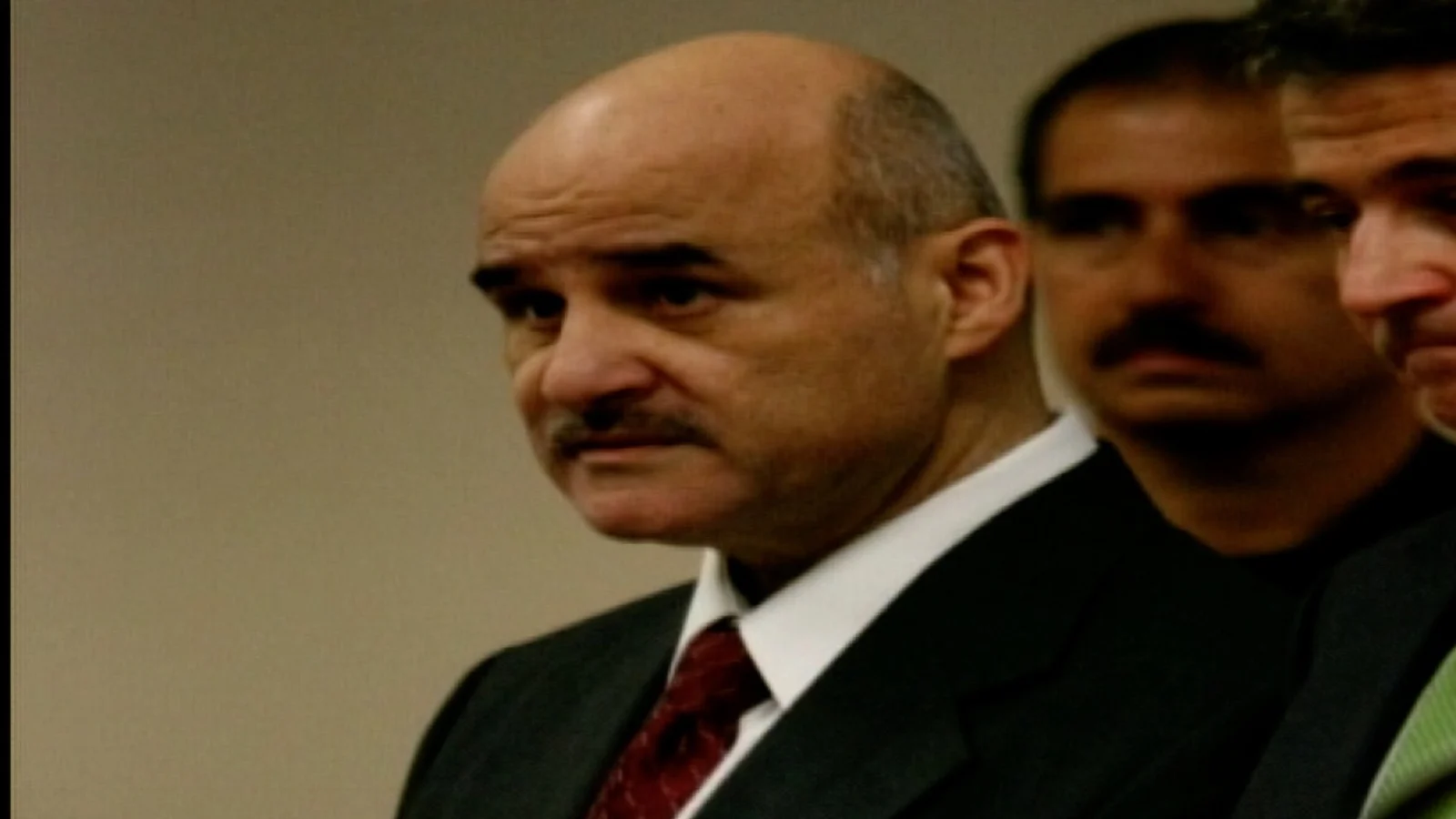 Altemio Sanchez in a dark suit and red tie standing in a Buffalo courtroom