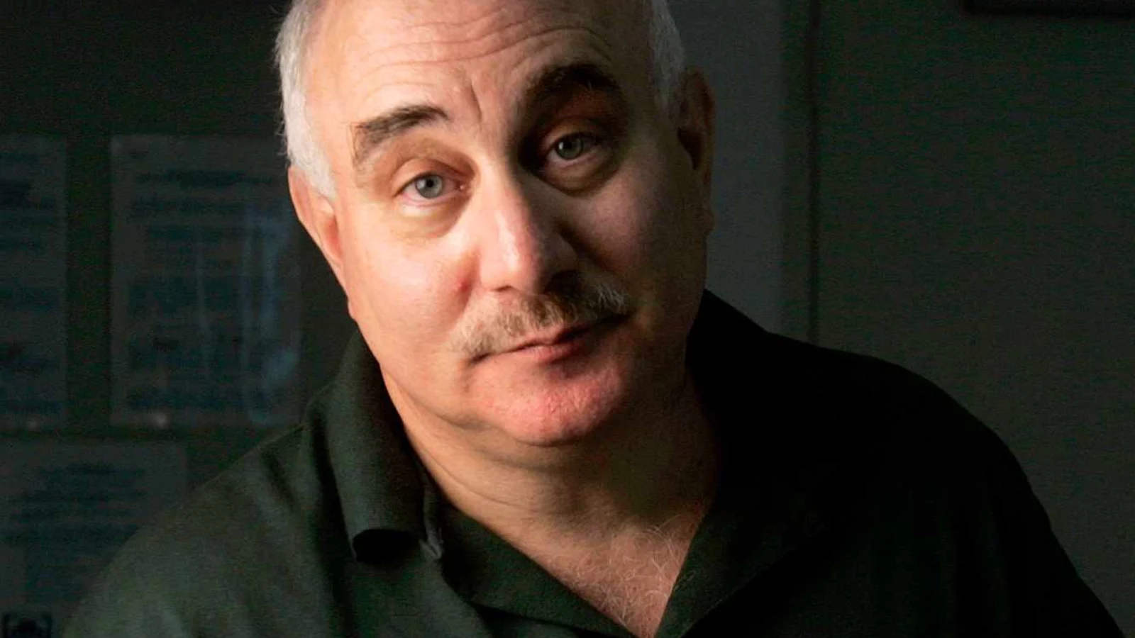 David Berkowitz, gray-haired and mustached, in a dark green prison shirt