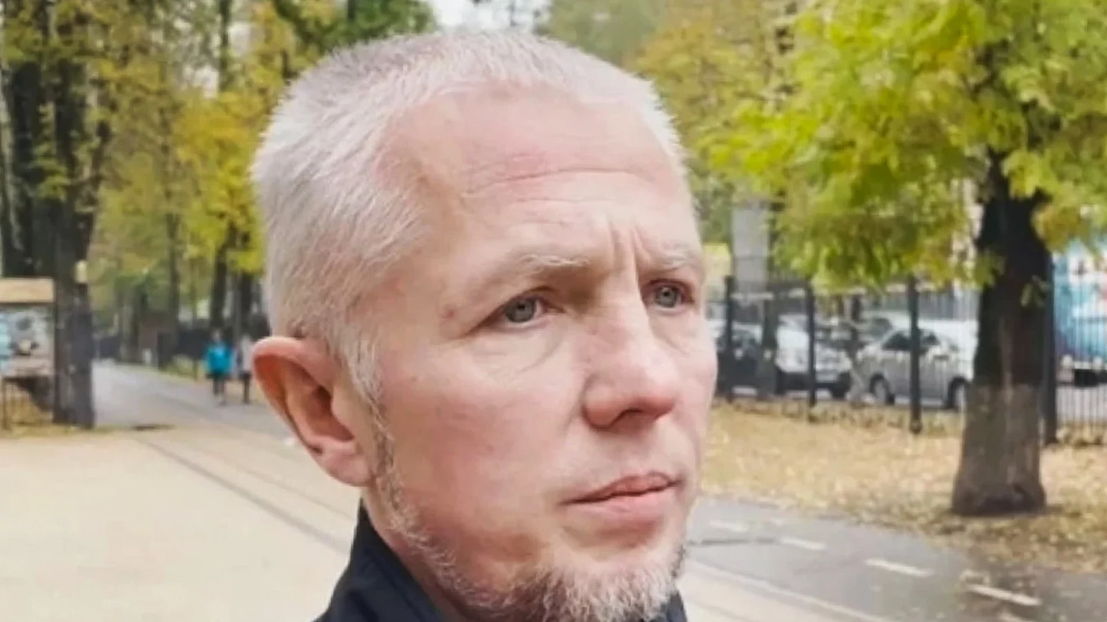 Alexei Gaskov, gray-haired, in a dark jacket, outdoors during an investigators' crime-scene visit