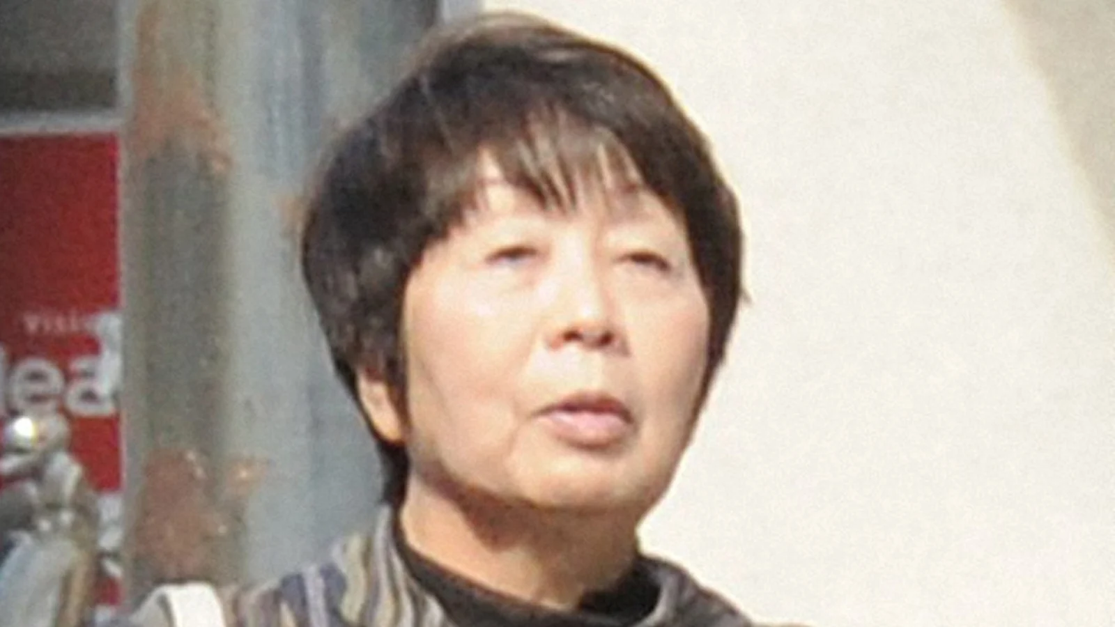 Chisako Kakehi, with short dark hair, outdoors in a striped jacket