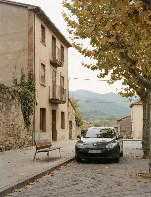 Illustration of a quiet cobbled street in a Catalan town in autumn, with a parked car and hills beyond. Not an actual scene from the case.