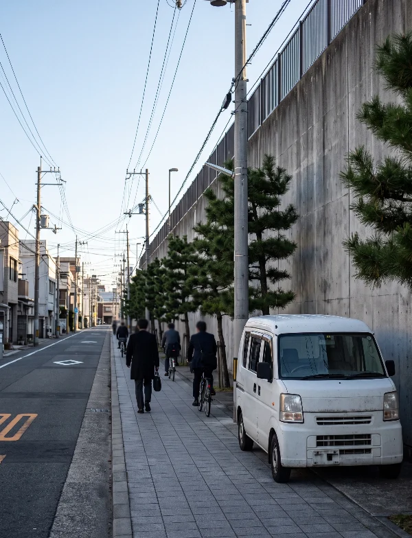 Illustration of a high concrete wall along a quiet Japanese street on a winter morning. Not an actual scene from the case.