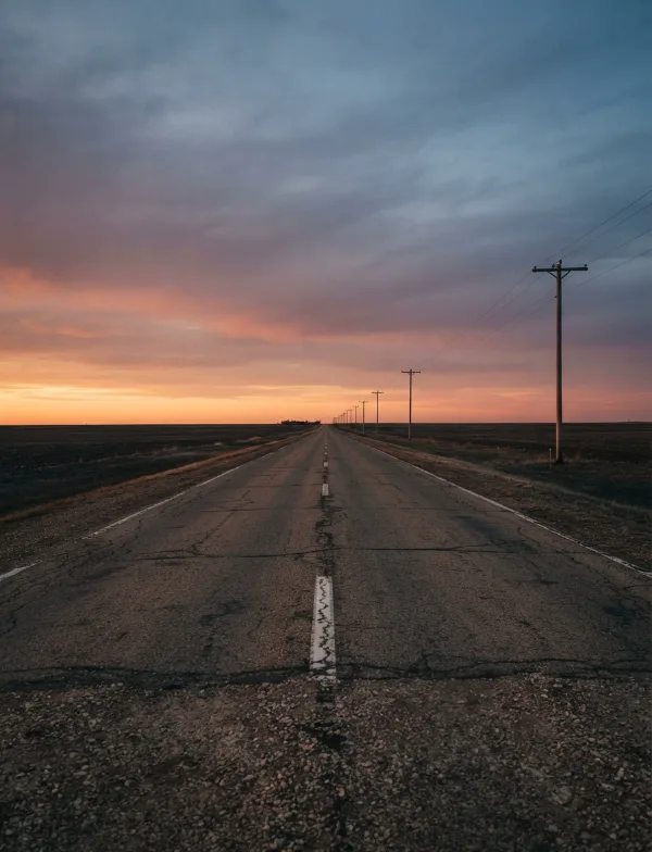 Illustration: empty two-lane country road at dusk